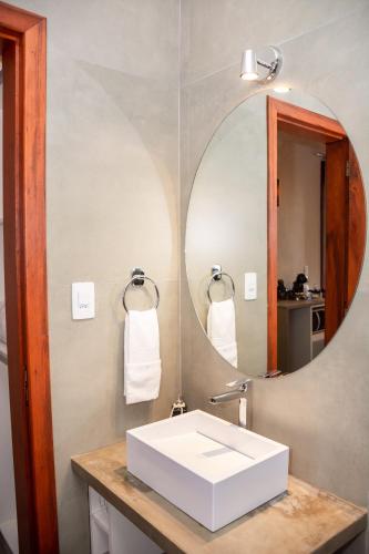 a bathroom with a white sink and a mirror at Cabana Sol - Estalagem Meraki, Cunha SP in Cunha