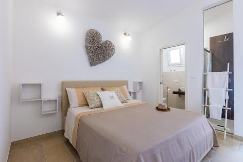 a bedroom with a bed with a heart on the wall at Valentinus in Ugento