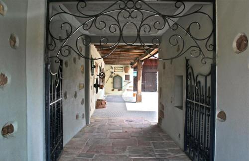an entrance to an alley with a wrought iron gate at Hôtel L'Auberge Alsacienne in Eguisheim