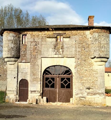 an old stone building with a large door at Gîte de l'Octroy Poitou in Oiron