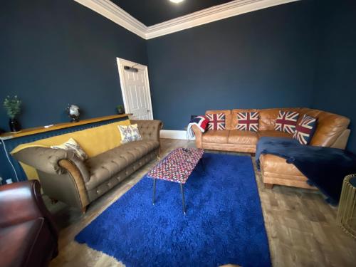 a living room with two couches and a blue rug at Blackpool Abode - The Cinema House in Blackpool