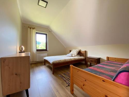 a bedroom with two beds and a window at Apartament pod lipką in Lutowiska