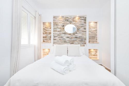 a white bedroom with a white bed and a mirror at Marmoles 21, City Center Apartment in Málaga