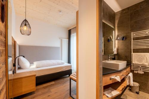 a bedroom with a bed and a sink and a mirror at Landhotel Zum Goldenen Kreuz in Moosbach