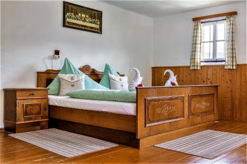 a bedroom with a bed with green and white pillows at Vordersattlegghofhütte in Hüttau