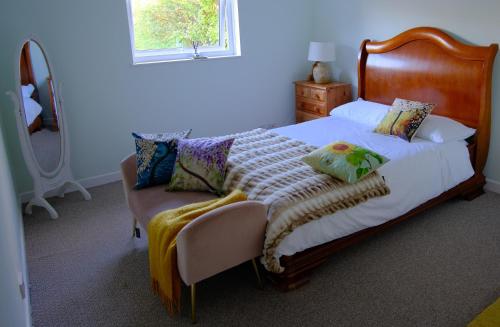 a bedroom with a bed and a chair and a mirror at Perfect Getaway in Cardigan