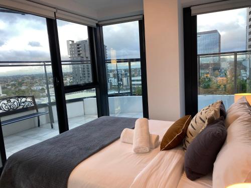 1 dormitorio con 1 cama grande y ventanas grandes en Apartment with nice view in Boxhill 8A, en Box Hill