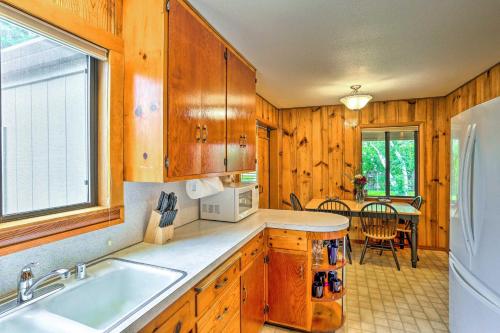 a kitchen with wooden cabinets and a white refrigerator at Shasta Lake Escape Near Redding with Fire Pit! in Shasta Lake