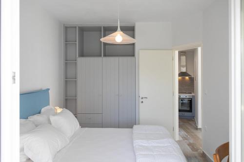 a bedroom with white walls and a bed with white pillows at MNP Apartments in Engares