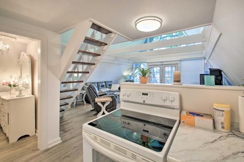 a kitchen with a stove and a spiral staircase at Deck, Boat Slip and Views Lake Hamilton Cabin! in Hot Springs