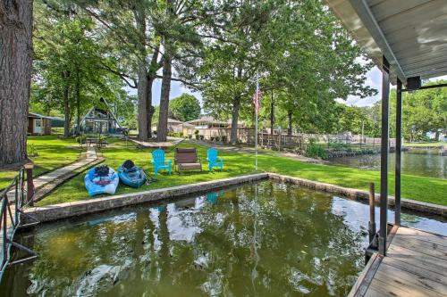a house with a pond with two boats in it at Deck, Boat Slip and Views Lake Hamilton Cabin! in Hot Springs