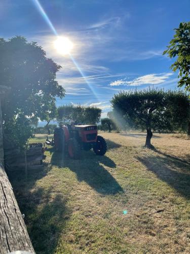 a tractor parked in a field with a tree at Lodge - Le Clos Devançon in Gréoux-les-Bains