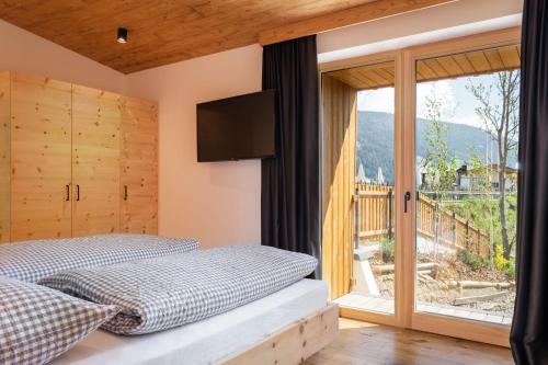 a bedroom with a bed and a large window at Apartments Hermann's in San Candido