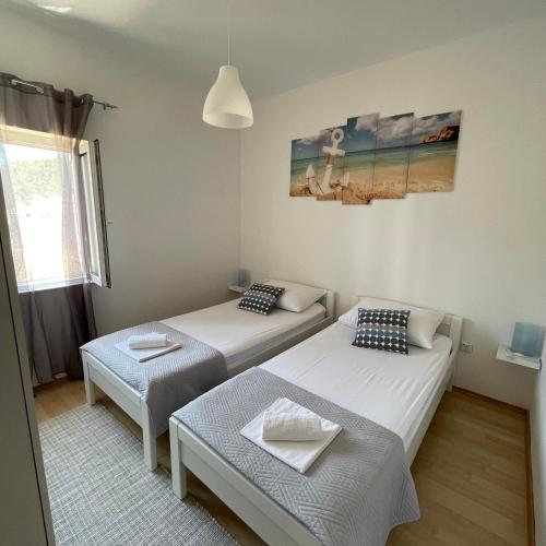 a room with two beds and a table in it at Apartman Emilija in Vinišće
