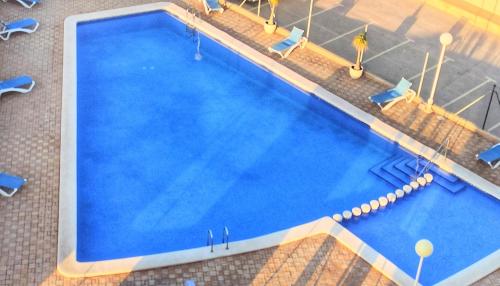 an overhead view of a large blue swimming pool at Apartamentos Hondahouse en Playa Honda Mar Menor, 1 o 2 dormitorios in Playa Honda