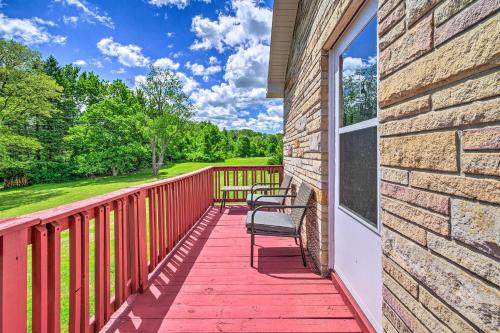 a red deck with two chairs and a window at Roomy Montour Falls Retreat with Private Pool! in Montour Falls
