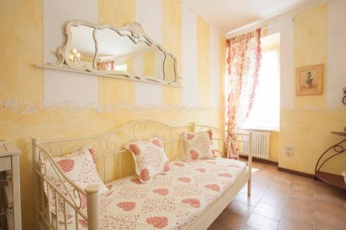 a bedroom with a bed with pink and white pillows at Relais De La Place in Desenzano del Garda