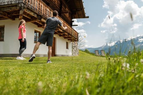 a man and a woman playing a game of frisbee at Chalet Ulten in Santa Valburga St. Walburg