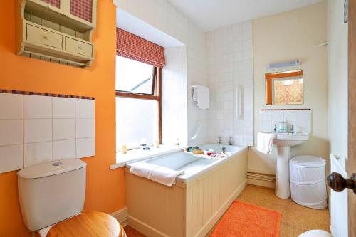 a bathroom with a tub and a toilet and a sink at Finest Retreats - Sunny Bank in Grange Over Sands