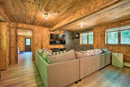 a living room with a large couch and a television at Wilmington Chalet with Hot Tub Less Than 8 Mi to Mount Snow! in Wilmington