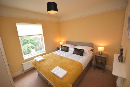 a bedroom with a large bed and a window at Luxurious Victorian Home by the sea - Myana House in Lowestoft