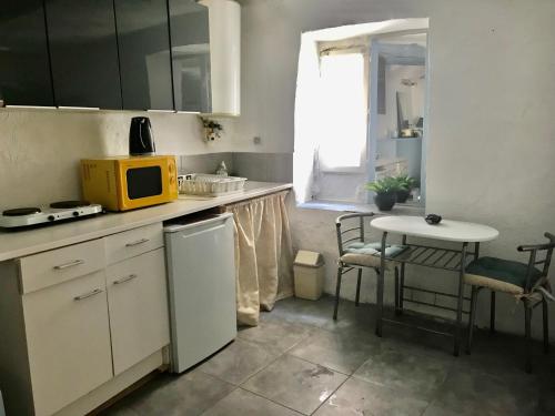 a kitchen with a small table and a yellow microwave at Apartment Des Romains in Sospel