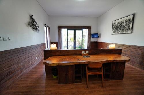 a large wooden table in a room with a window at Adil Villa & Resort in Ubud