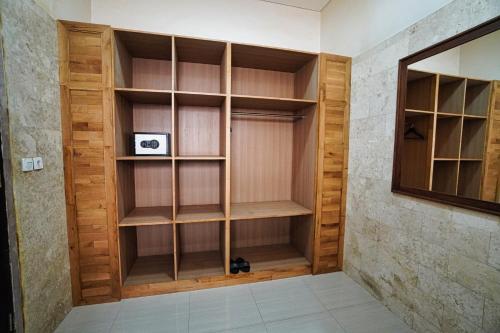 a walk in closet with wooden shelves at Adil Villa & Resort in Ubud