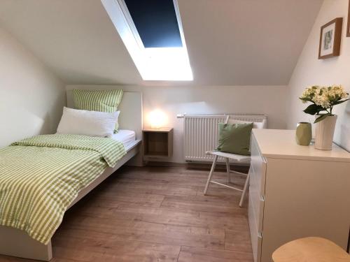 a small bedroom with a bed and a desk at Haus Am Spitalgarten für 10 Personen in Gundelfingen an der Donau