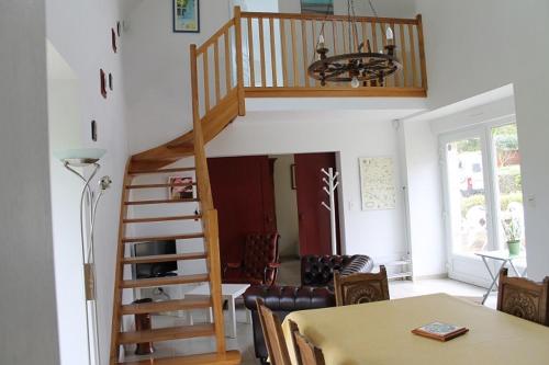 a staircase in a living room with a table and a dining room at La Maison de Lésa in Kerandraou