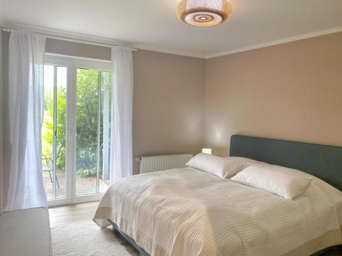 a bedroom with a bed and a large window at Rügen Westend - Wohnung 8 in Gingst