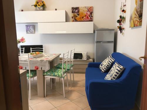 een keuken met een tafel en een blauwe stoel bij Casa Sangion in Caorle