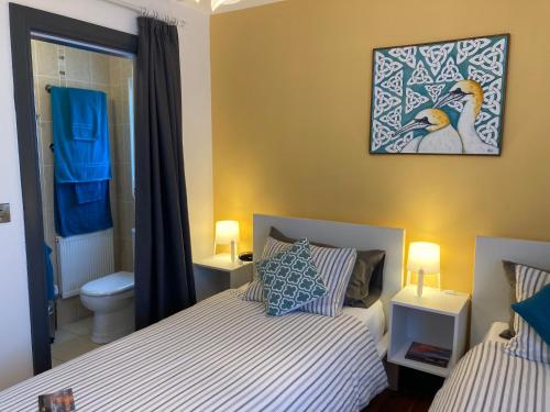 1 dormitorio con 2 camas y baño en Uisce Beatha House B&B en Portmagee