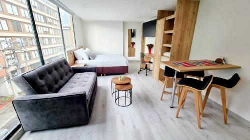 a living room with a couch and a bed at Toscana LOFT - Apartasuites in Bogotá