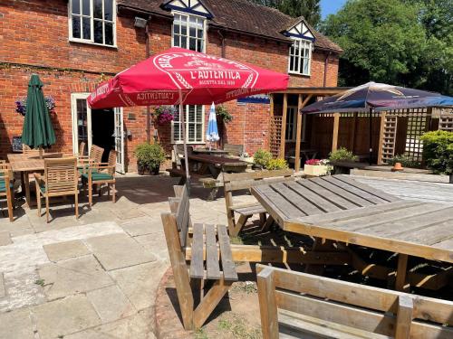 un patio con mesas y sombrillas frente a un edificio en THE SHEARS INN en Marlborough