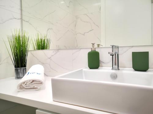 a white bathroom with a sink and a mirror at OportoView Prestige Apartment in Porto