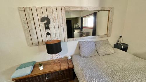 une chambre avec un lit et un miroir au mur dans l'établissement Studio Cocooning hauteur de Saint-Raphaël, à Saint-Raphaël