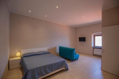 a bedroom with a bed and a blue chair at HelloElba Appartamento Il Faro in Portoferraio