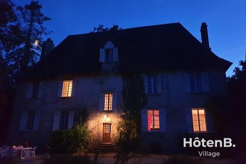 uma casa com as luzes acesas à noite em Le château du Fraysseix à Roziers-Saint-Georges em Roziers-Saint-Georges