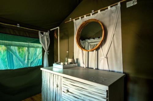 a bathroom with a mirror and a dresser with a sink at Urban Camp in Windhoek