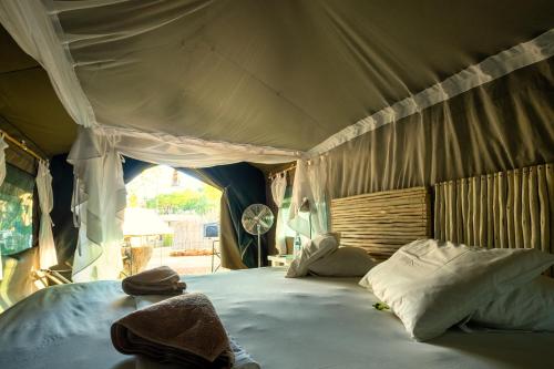 a bedroom with a large bed in a tent at Urban Camp in Windhoek