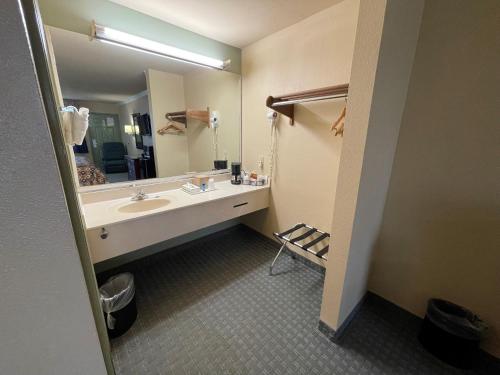 a bathroom with a sink and a large mirror at Americas Best Value Inn Hobby Airport in Houston