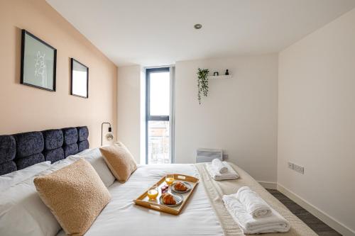 - une chambre avec un lit et un plateau de nourriture dans l'établissement Stunning 2 bed apt with free parking close to CC, à Manchester