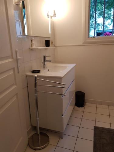 une salle de bain blanche avec un lavabo et un miroir dans l'établissement Studio Domaine des Oliviers, à Sarlat-la-Canéda
