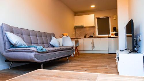 a living room with a couch and a kitchen at Natura Cantabria in Santillana del Mar