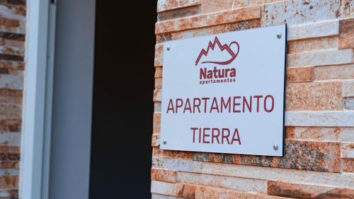 una señal en el lateral de un edificio de ladrillo en Natura Cantabria, en Santillana del Mar