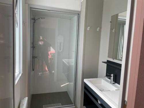 uma pessoa tirando uma foto de um chuveiro em uma casa de banho em Mobilhome tout confort M9 domaine de Lanniron em Quimper