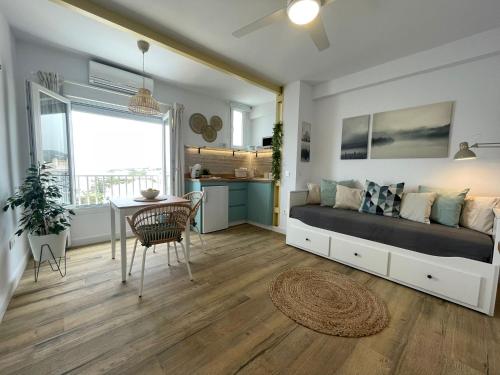 a bedroom with a bed and a table and a kitchen at Studio on the Beach Front in Sitio de Calahonda