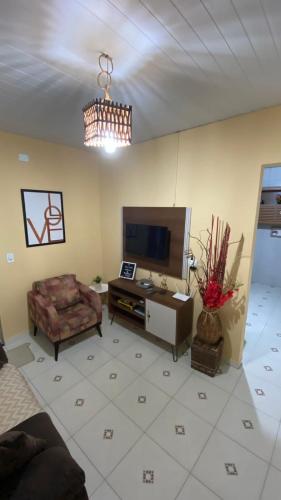 a living room with a couch and a tv at Manancial Flats in Maragogi