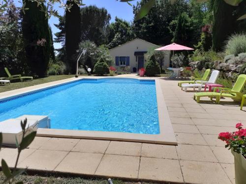 une piscine avec des chaises et un parasol dans l'établissement Studio Domaine des Oliviers, à Sarlat-la-Canéda